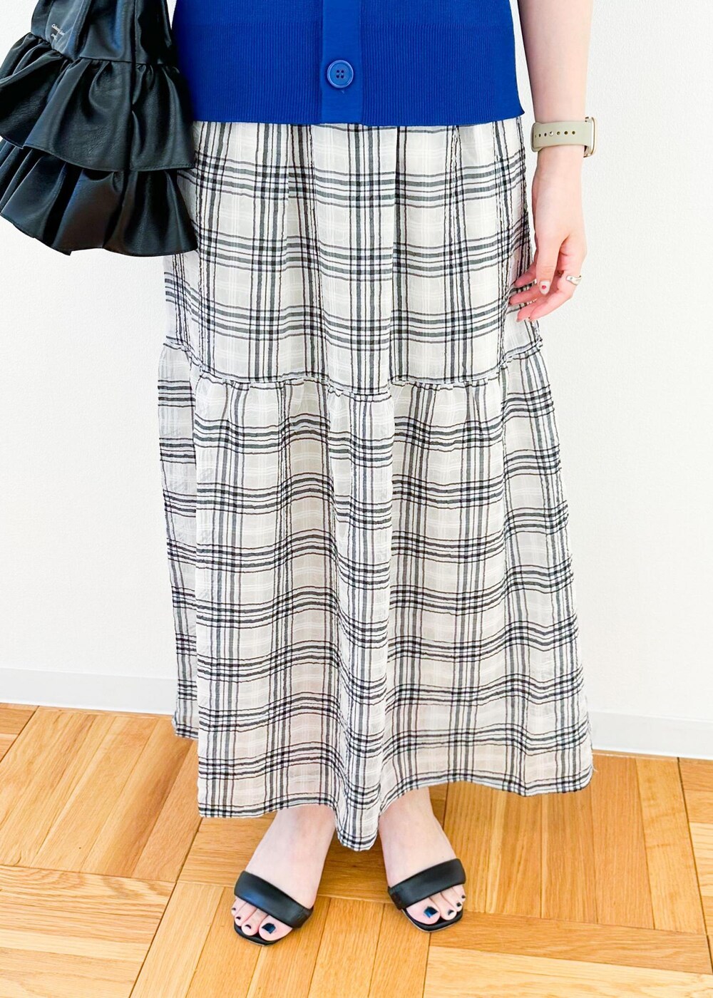 ブラック系のトートバッグ、ブルー系のベスト、ブラック系のスカートを着用したレディースの夏コーディネートの7枚目の写真