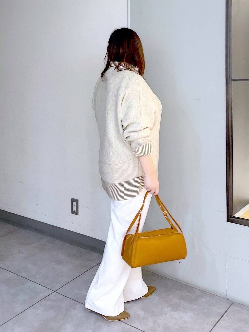 ブラウン系のパンプス、ベージュ系のニット/セーター、ホワイト系のその他パンツを着用したレディースの冬コーディネートの3枚目の写真
