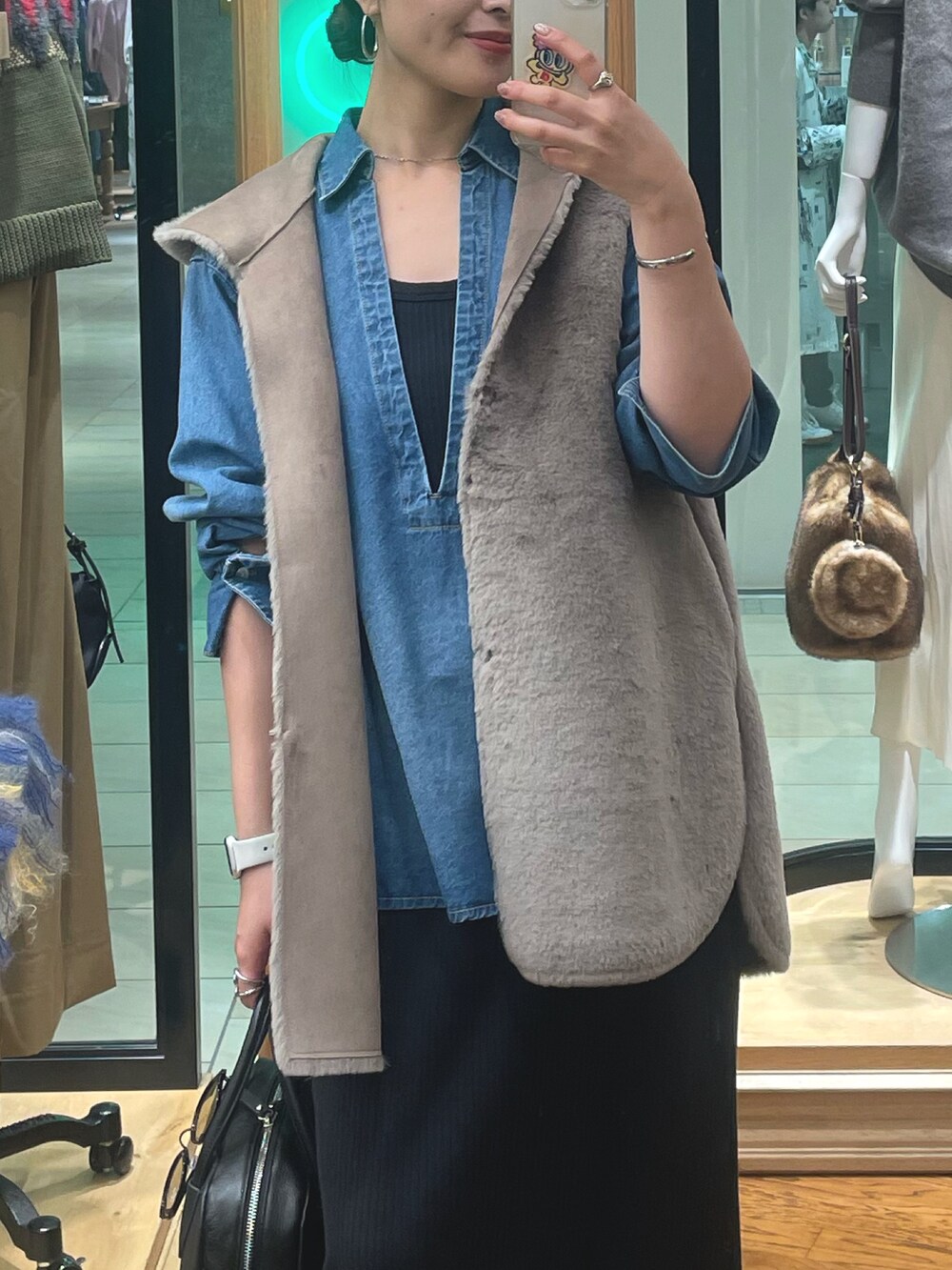 ブラック系のブーツ、ブラック系のボストンバッグ、ブラック系のワンピースを着用したレディースの秋コーディネートの3枚目の写真