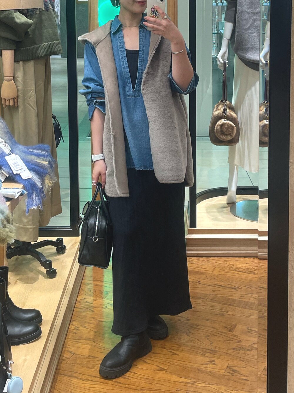 ブラック系のブーツ、ブラック系のボストンバッグ、ブラック系のワンピースを着用したレディースの秋コーディネートの2枚目の写真