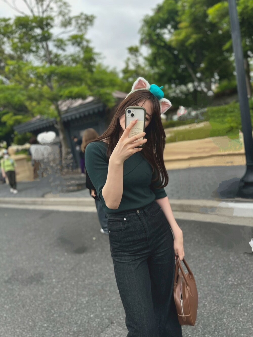 ベージュ系のスニーカー、ブラック系のデニムパンツ、グリーン系のニット/セーターを着用したレディースの夏コーディネートの2枚目の写真