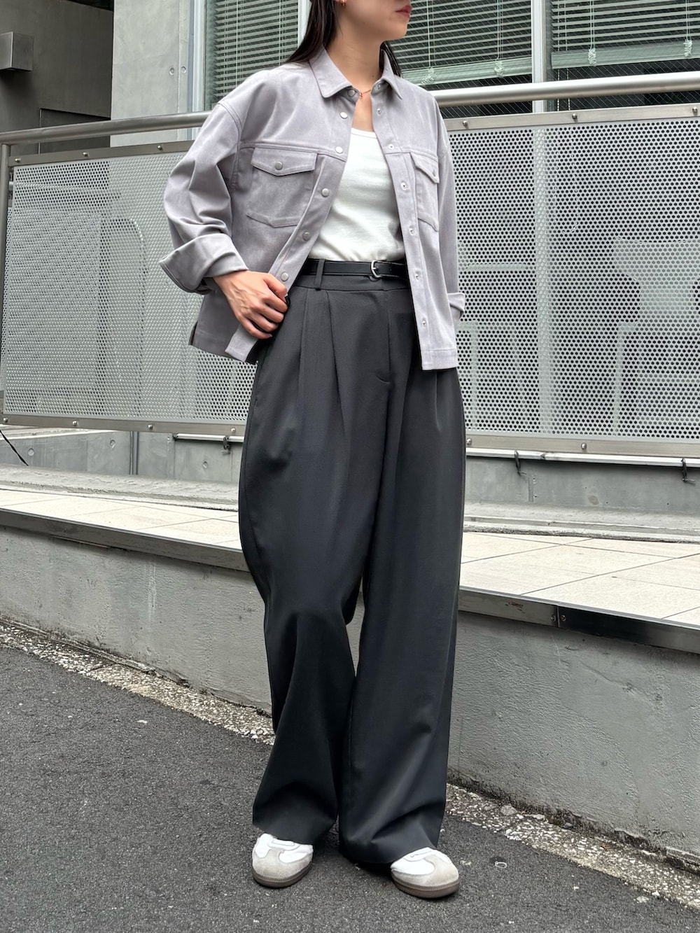 グレー系のシャツ/ブラウス、グレー系のスラックス、ホワイト系のスニーカーを着用したレディースの秋コーディネートの3枚目の写真