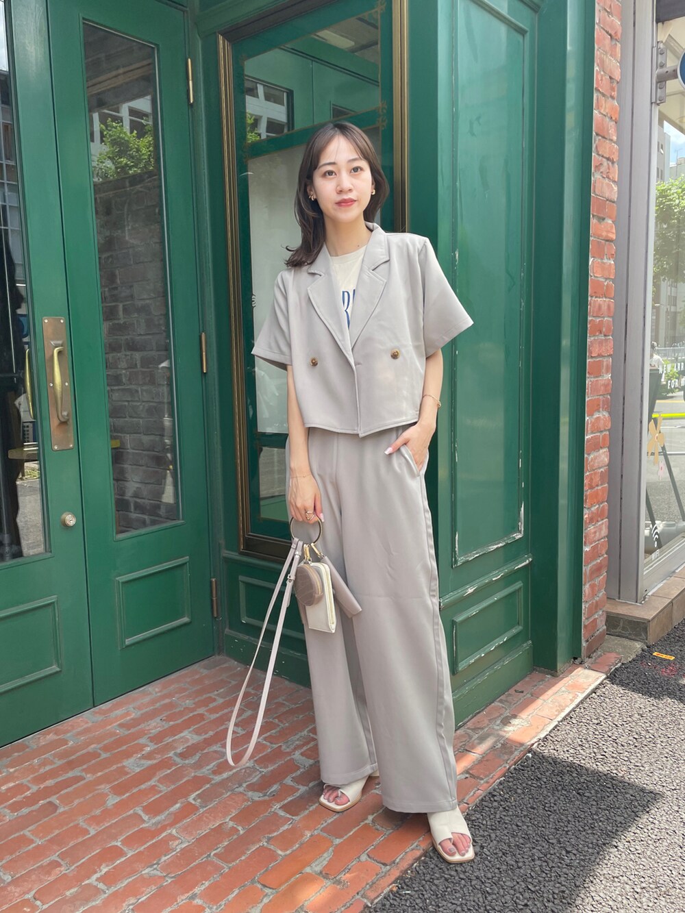 ベージュ系のセットアップ、ホワイト系のサンダル、ベージュ系のショルダーバッグを着用したレディースの夏コーディネートの3枚目の写真
