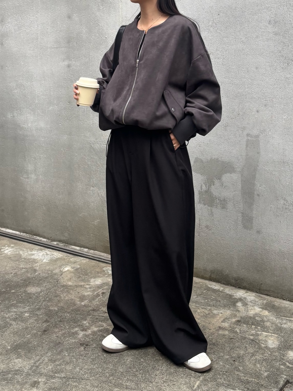 ブラック系のスラックス、ブラック系のブルゾン、ブラック系のTシャツ/カットソーを着用したレディースの冬コーディネートの3枚目の写真