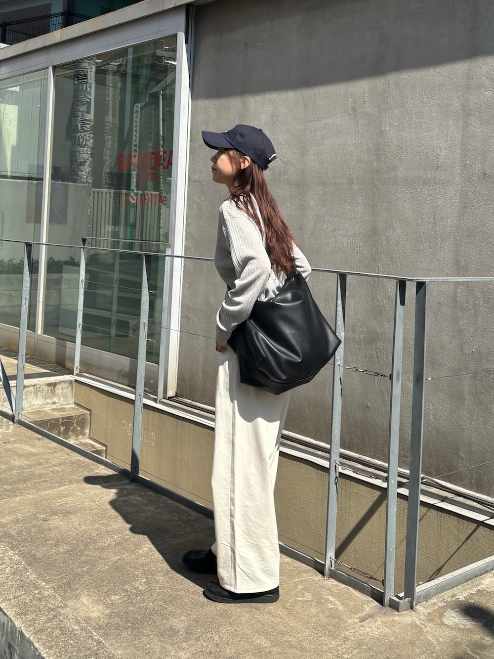 ホワイト系のその他パンツ、グレー系のカーディガン/ボレロ、ブラック系のショルダーバッグを着用したレディースの春コーディネートの4枚目の写真