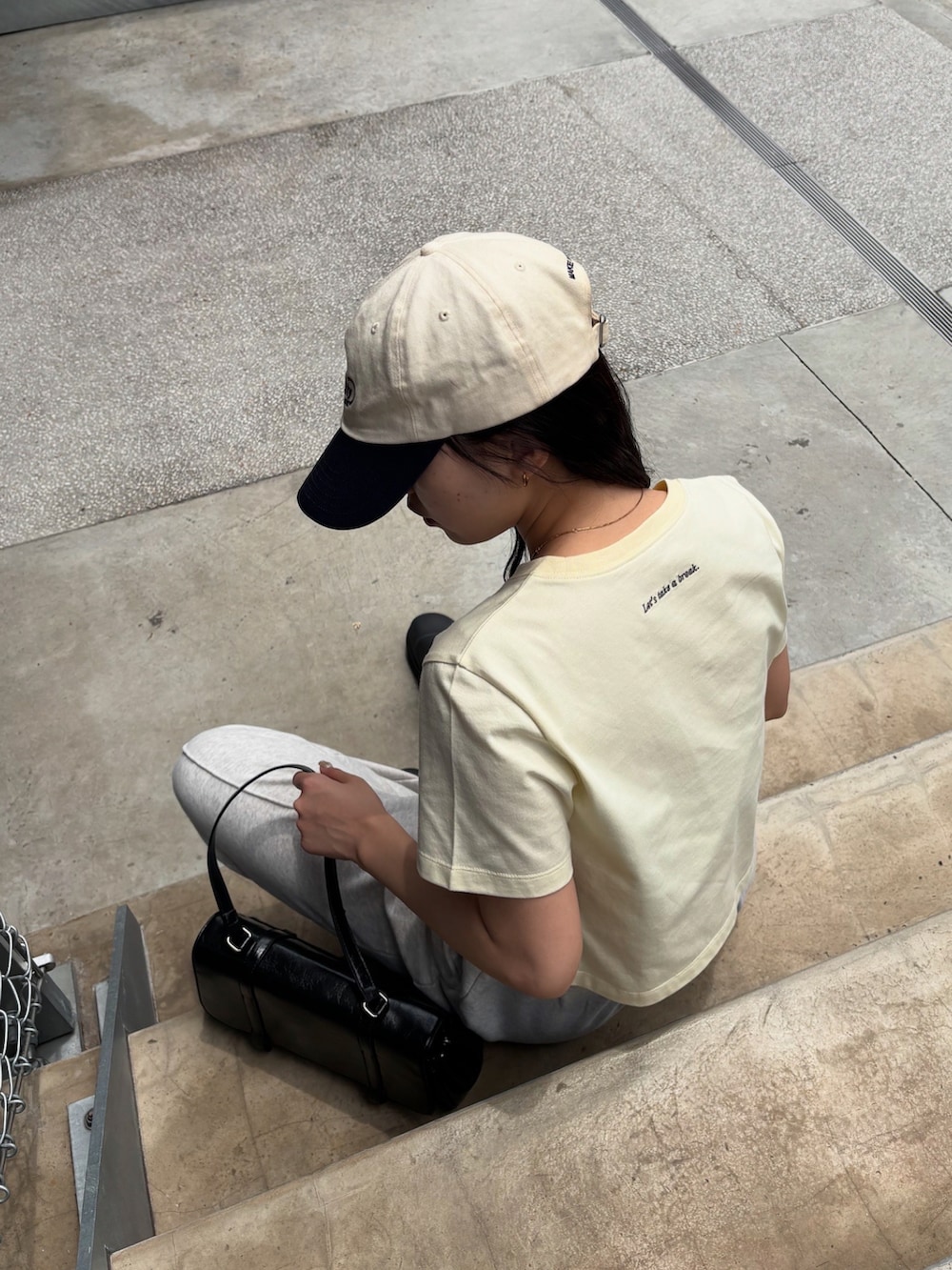 イエロー系のTシャツ/カットソー、ホワイト系のスウェットパンツ、ブラック系のレインシューズを着用したレディースの夏コーディネートの4枚目の写真