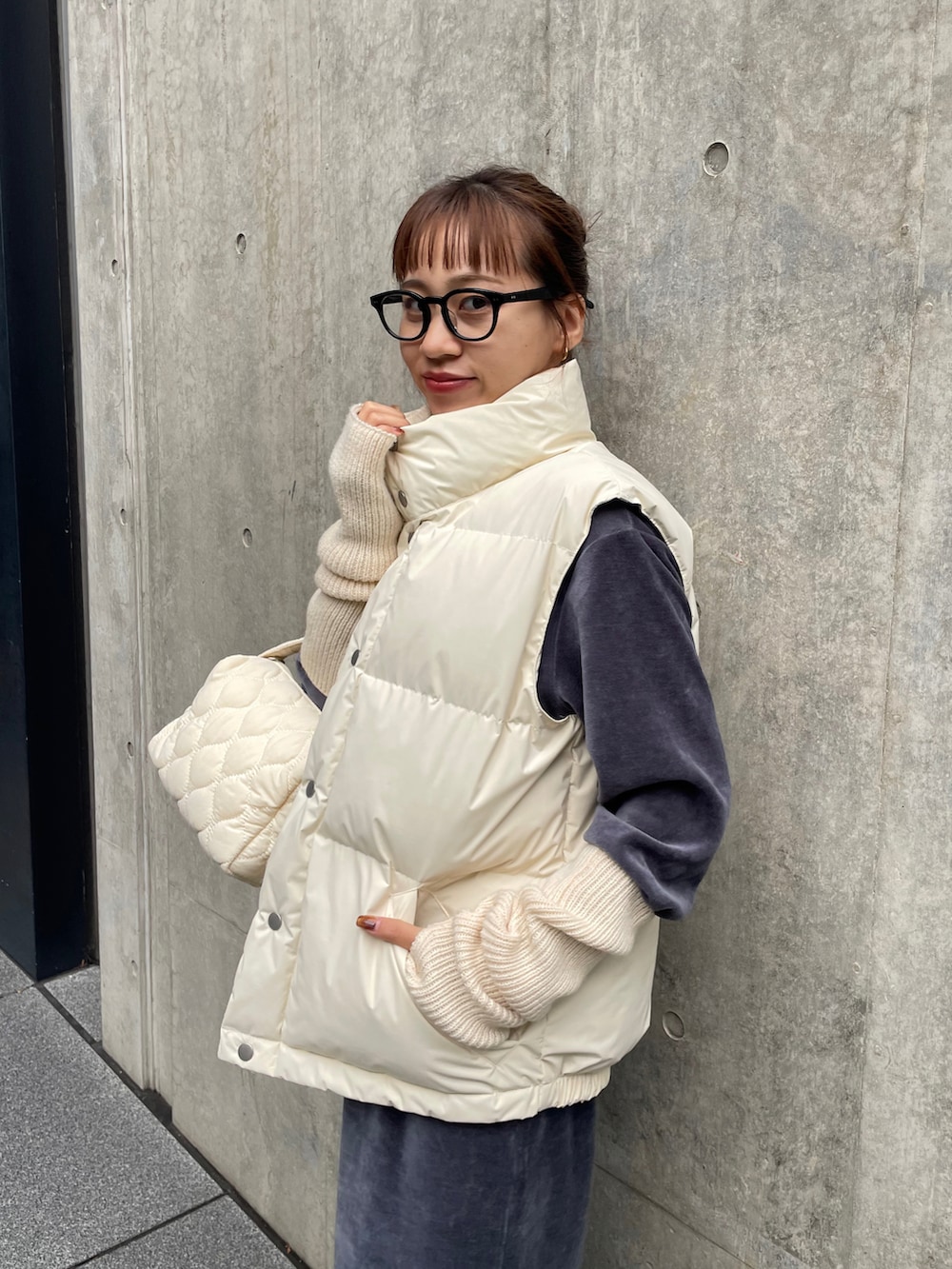 ブラック系のブーツ、ホワイト系のショルダーバッグ、ブラック系のメガネを着用したレディースの秋コーディネートの3枚目の写真