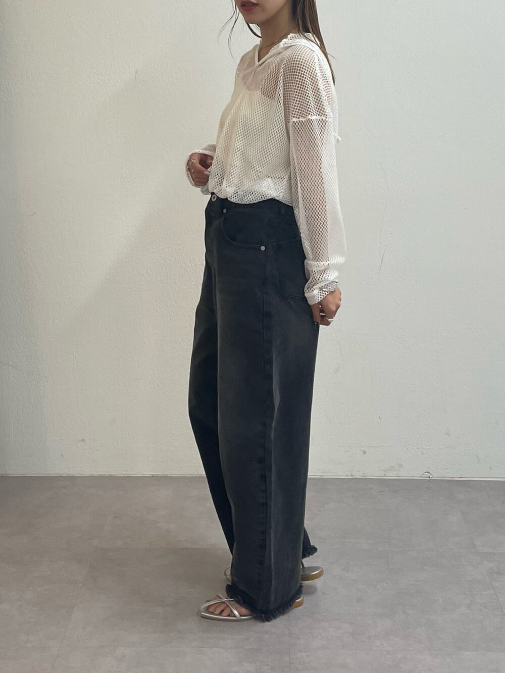 ブラック系のデニムパンツ、シルバー系のサンダル、ホワイト系のパーカーを着用したレディースの夏コーディネートの2枚目の写真