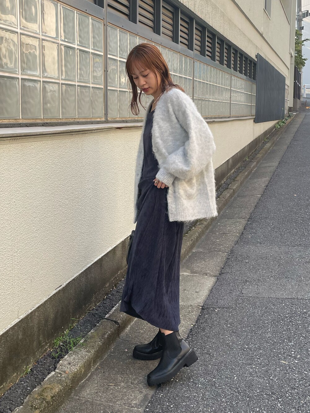 ブルー系のワンピース、グレー系のカーディガン/ボレロ、ブラック系のブーツを着用したレディースの秋コーディネートの2枚目の写真