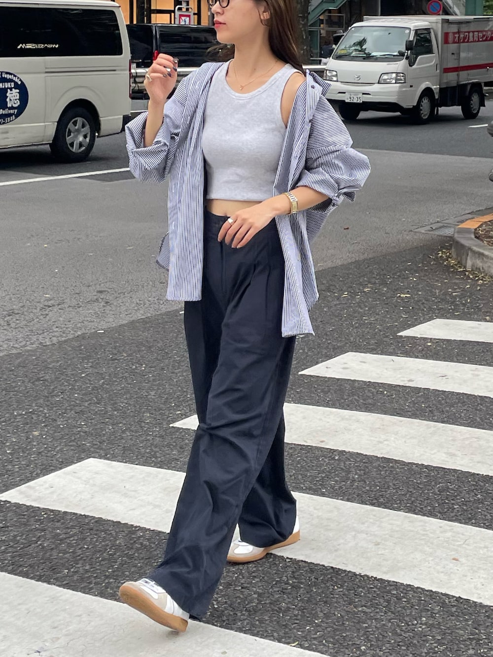 ブラック系のショルダーバッグ、ブルー系のその他パンツ、ホワイト系のスニーカーを着用したレディースの秋コーディネートの3枚目の写真