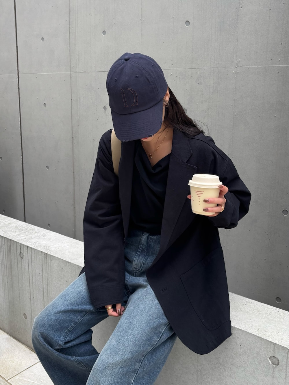 ブルー系のデニムパンツ、ベージュ系のショルダーバッグ、ブラック系のTシャツ/カットソーを着用したレディースの冬コーディネートの3枚目の写真