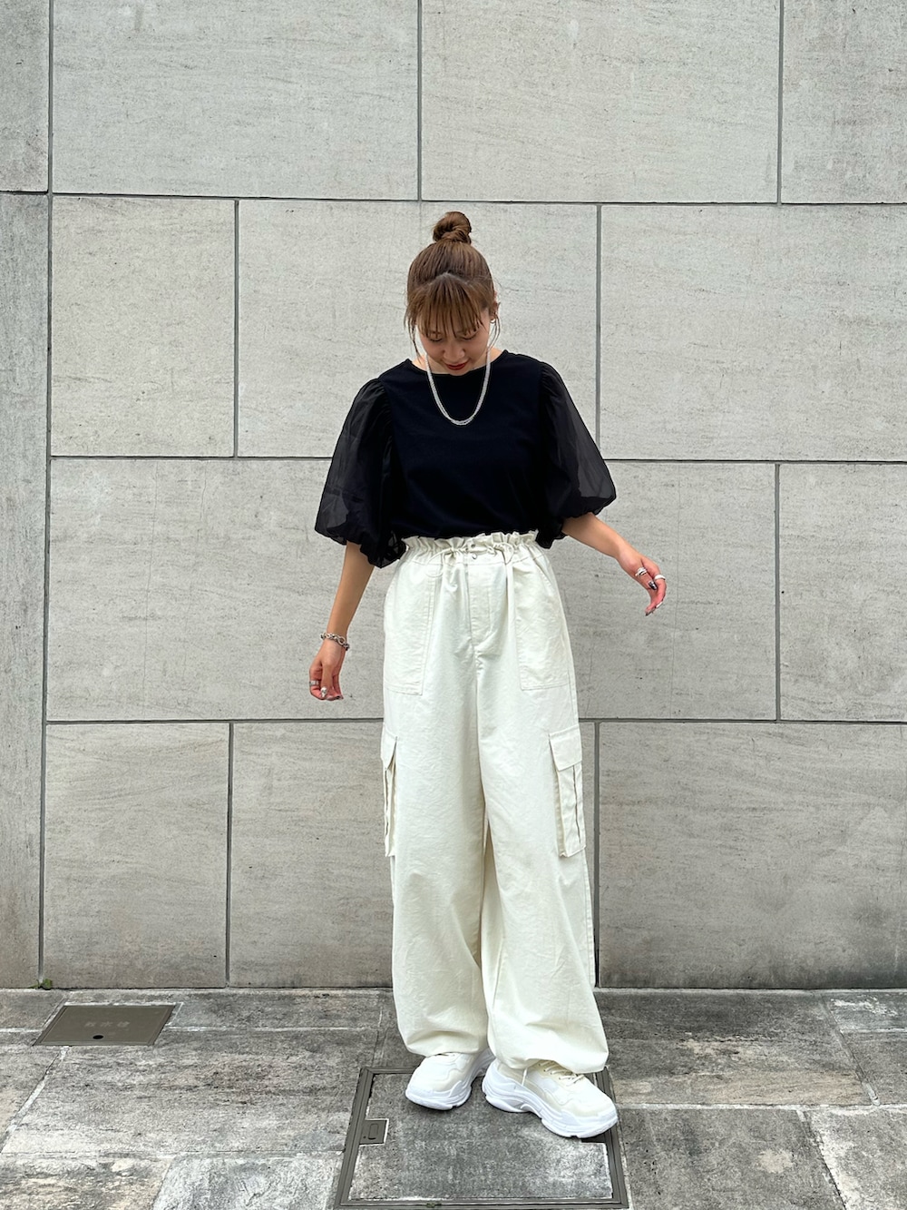 ブラック系のTシャツ/カットソー、ホワイト系のカーゴパンツ、ホワイト系のスニーカーを着用したレディースの夏コーディネートの2枚目の写真