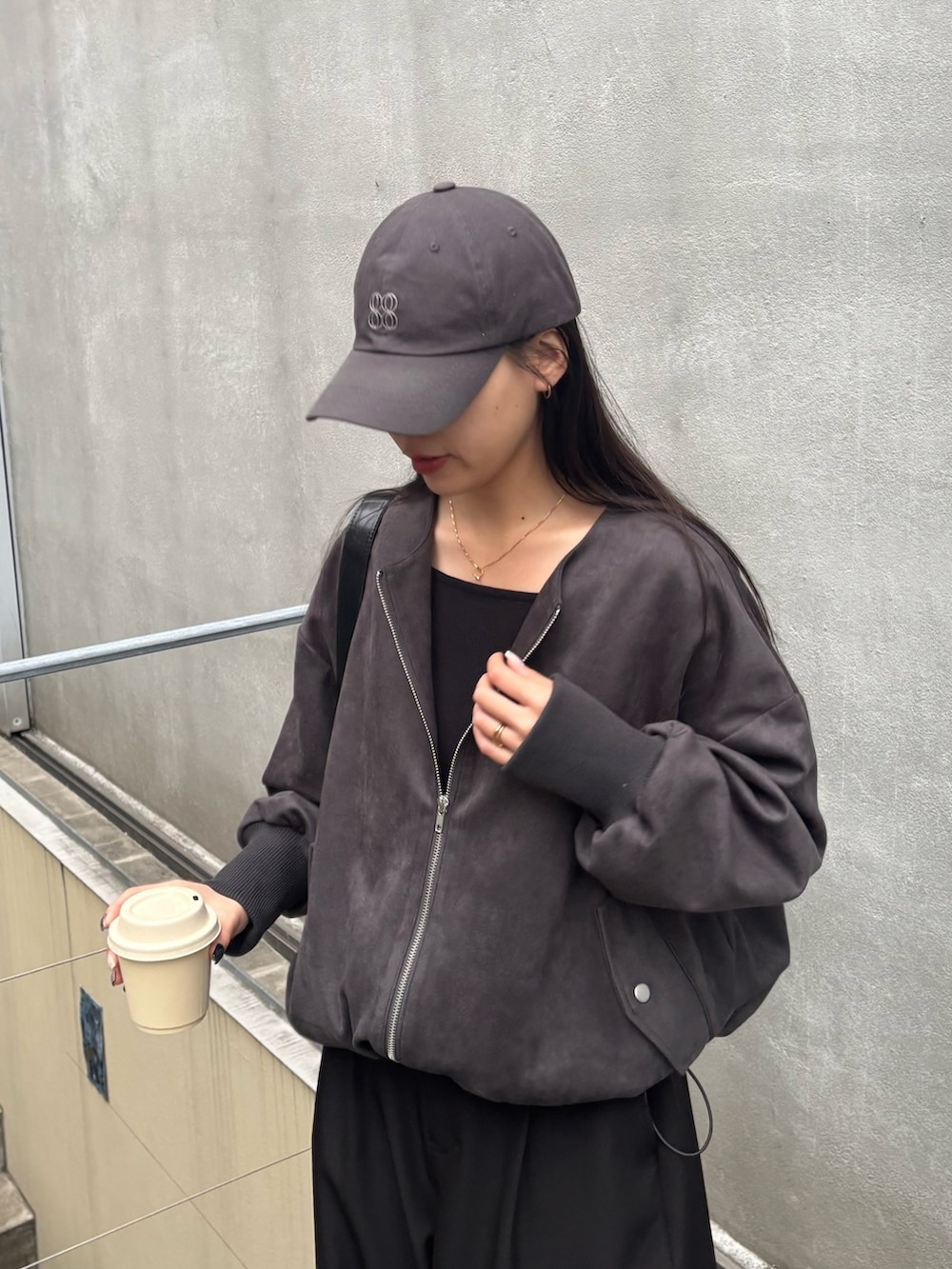 ブラック系のスラックス、ブラック系のブルゾン、ブラック系のTシャツ/カットソーを着用したレディースの冬コーディネートの2枚目の写真