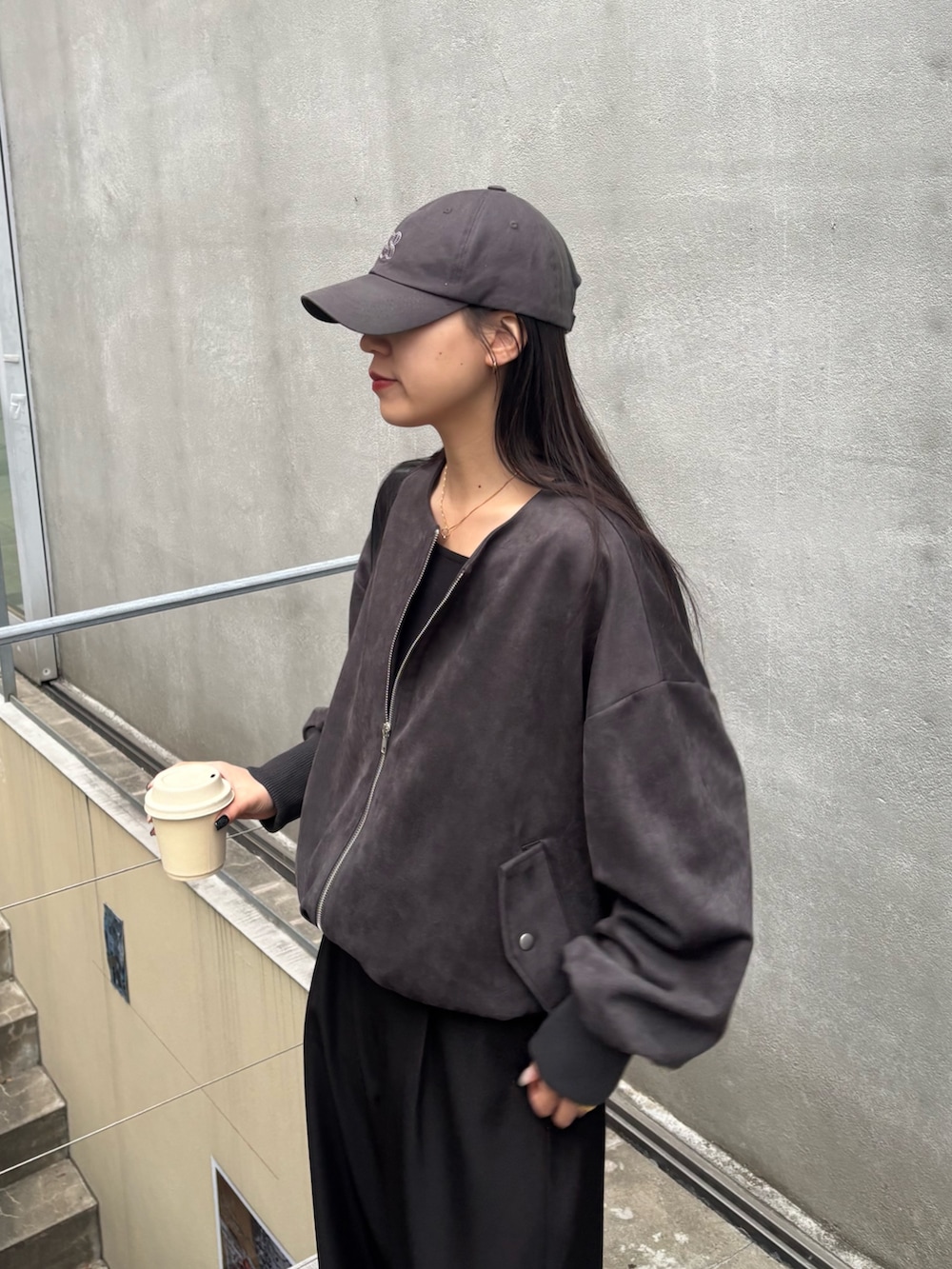 ブラック系のスラックス、ブラック系のブルゾン、ブラック系のTシャツ/カットソーを着用したレディースの冬コーディネートの5枚目の写真