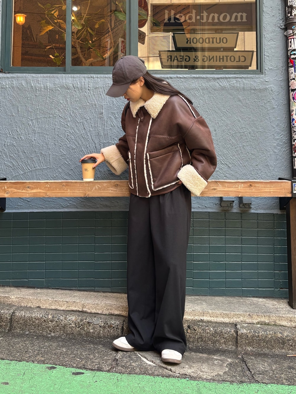 ブラウン系のブルゾン、ブラック系のその他パンツ、ホワイト系のスニーカーを着用したレディースの秋コーディネートの3枚目の写真