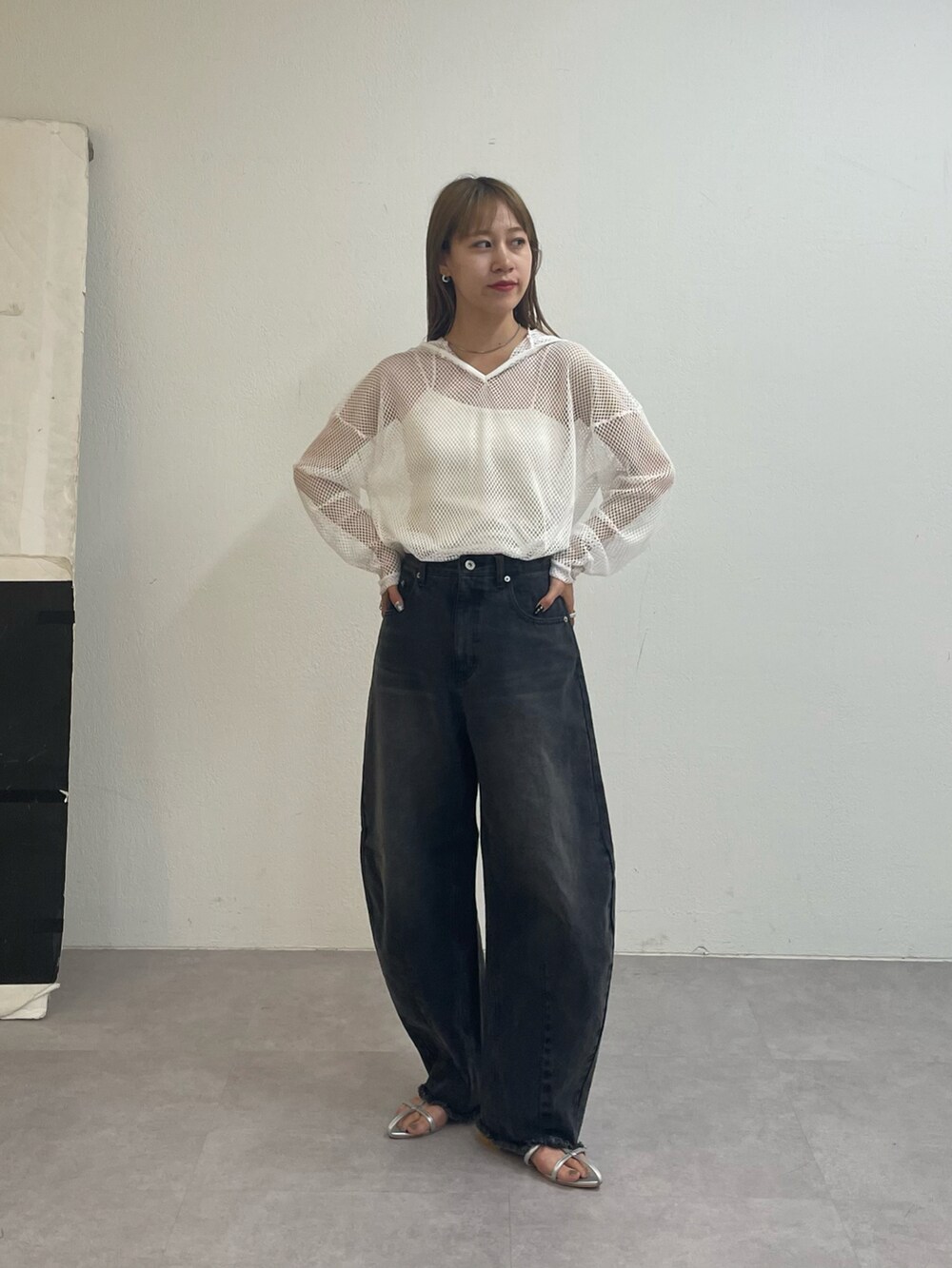 ブラック系のデニムパンツ、シルバー系のサンダル、ホワイト系のパーカーを着用したレディースの夏コーディネートの3枚目の写真