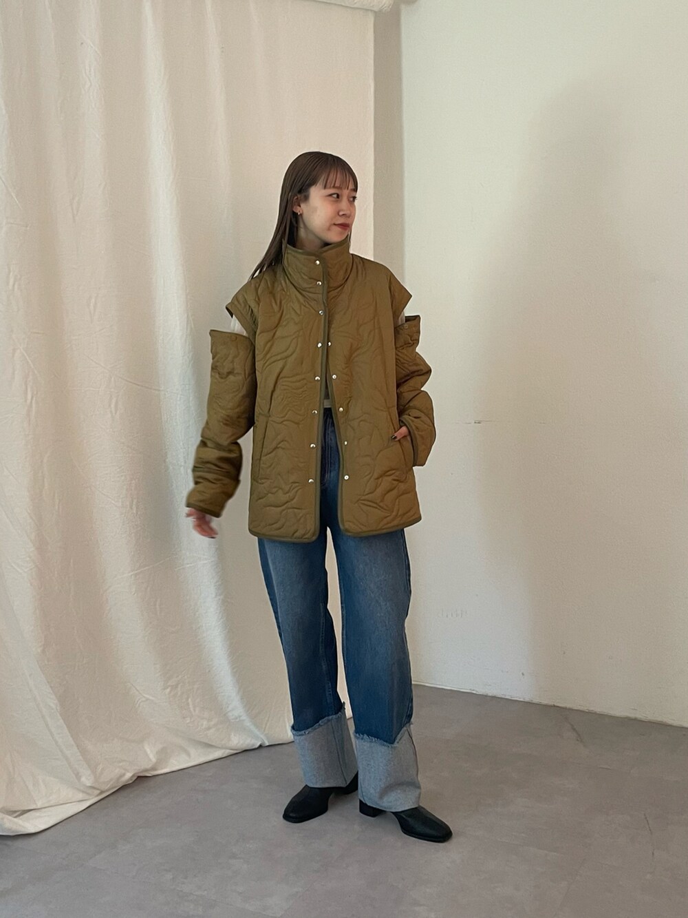 ブルー系のデニムパンツ、グリーン系のブルゾン、ブラック系のブーツを着用したレディースの夏コーディネートの4枚目の写真