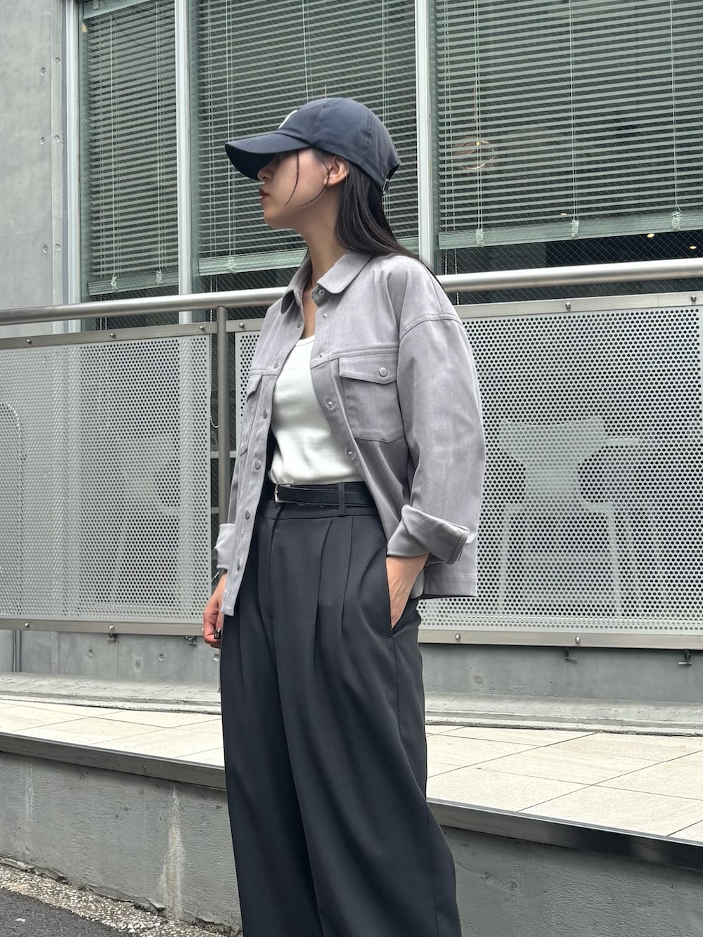 グレー系のシャツ/ブラウス、グレー系のスラックス、ホワイト系のスニーカーを着用したレディースの秋コーディネートの4枚目の写真