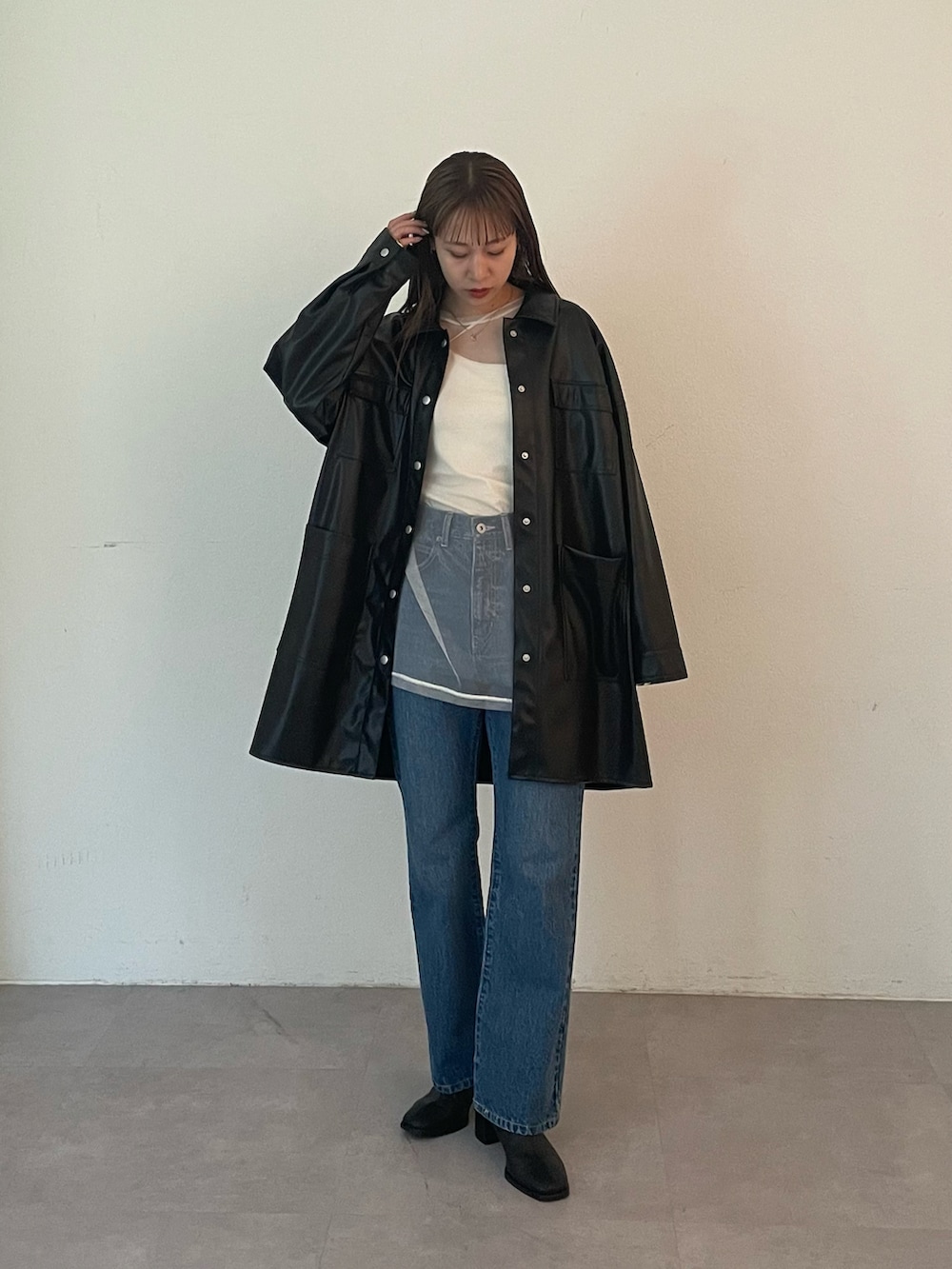 ブラック系のブーツ、ブルー系のデニムパンツ、ホワイト系のTシャツ/カットソーを着用したレディースの夏コーディネートの5枚目の写真