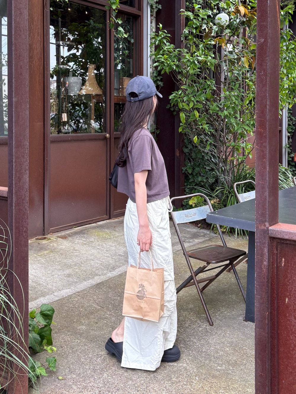 グレー系のTシャツ/カットソー、ホワイト系のスカート、ブラック系のレインシューズを着用したレディースの夏コーディネートの4枚目の写真