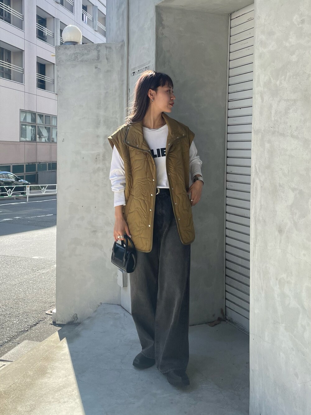 グリーン系のブルゾン、ホワイト系のTシャツ/カットソー、ブラック系のデニムパンツを着用したレディースの夏コーディネートの4枚目の写真