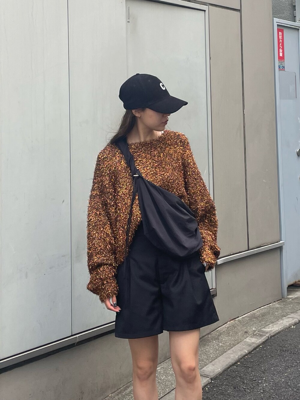 ブラウン系のニット/セーター、ホワイト系のスニーカー、ブラック系のその他パンツを着用したレディースの秋コーディネートの4枚目の写真