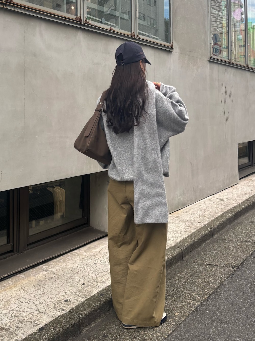 グレー系のニット/セーター、ブラウン系のショルダーバッグを着用したレディースの冬コーディネートの2枚目の写真
