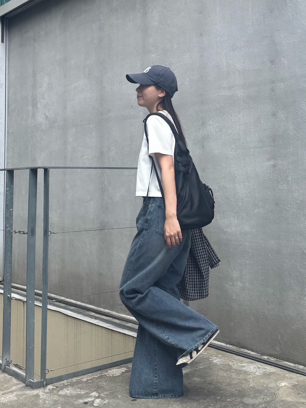 ブルー系のデニムパンツ、ホワイト系のTシャツ/カットソー、ブラック系のボディバッグ/ウエストポーチを着用したレディースの秋コーディネートの4枚目の写真