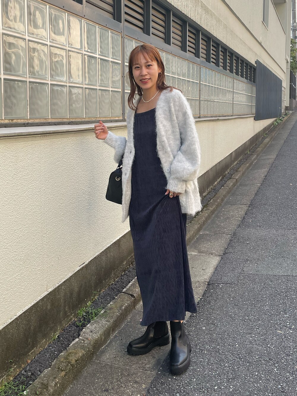 ブルー系のワンピース、グレー系のカーディガン/ボレロ、ブラック系のブーツを着用したレディースの秋コーディネートの4枚目の写真