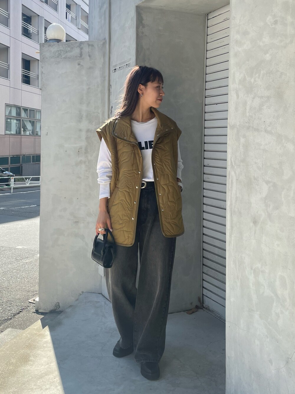 グリーン系のブルゾン、ホワイト系のTシャツ/カットソー、ブラック系のデニムパンツを着用したレディースの夏コーディネートの2枚目の写真