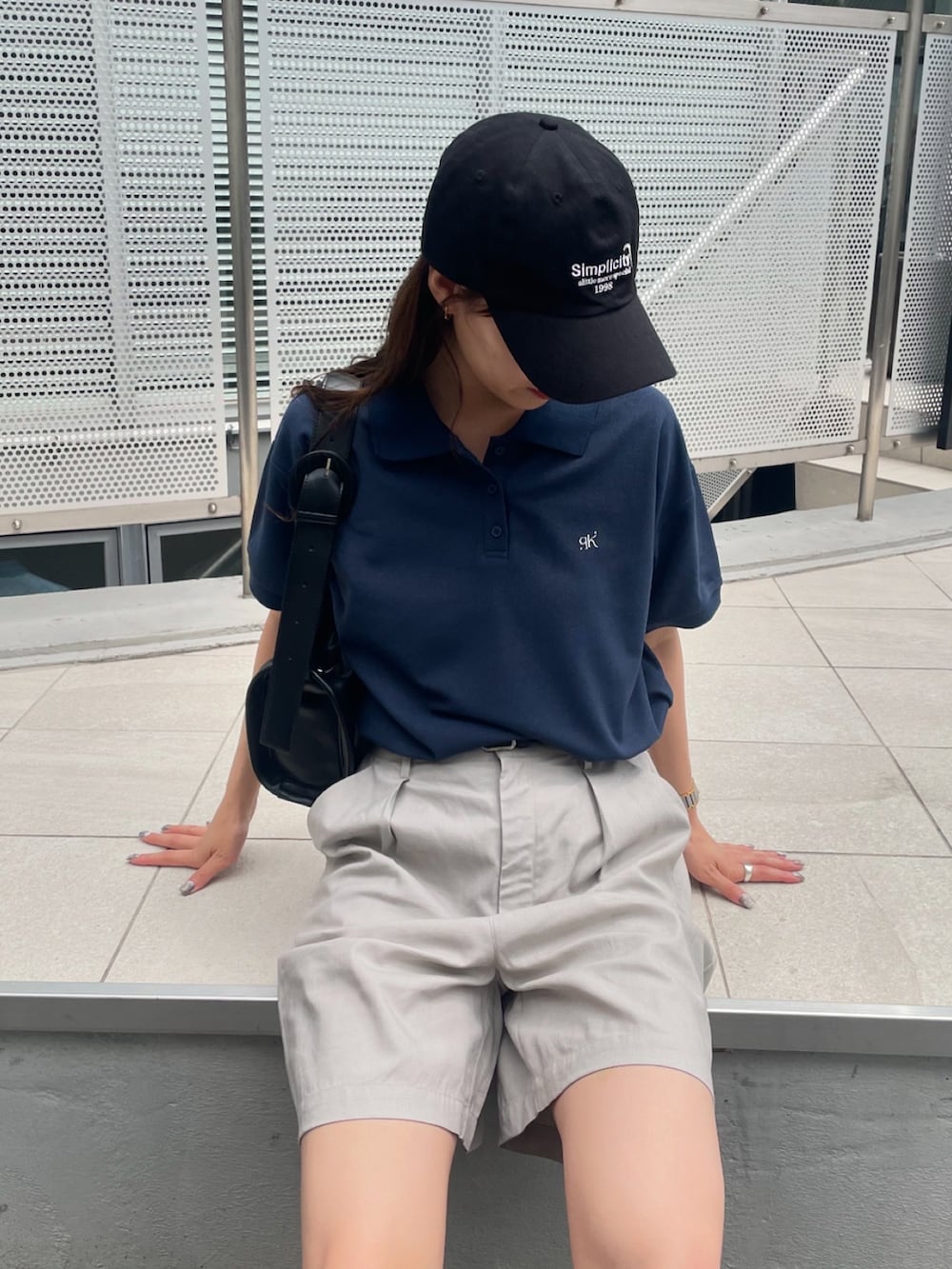 ブルー系のポロシャツ、ベージュ系のその他パンツ、ブラック系のスニーカーを着用したレディースの夏コーディネートの2枚目の写真