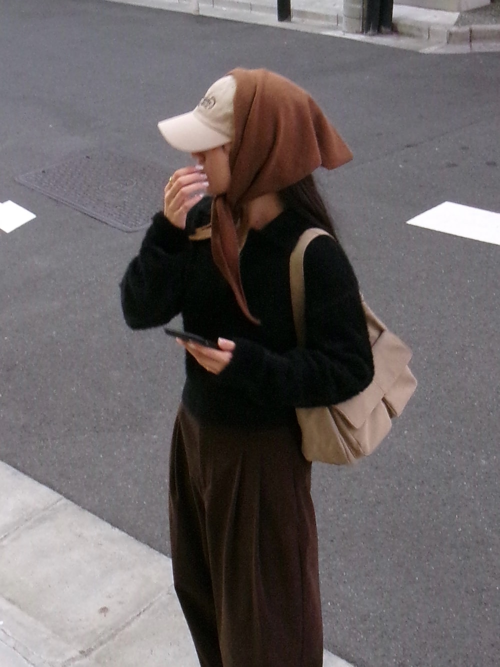 ブラック系のニット/セーター、ベージュ系のショルダーバッグ、ブラウン系のその他パンツを着用したレディースの秋コーディネートの3枚目の写真