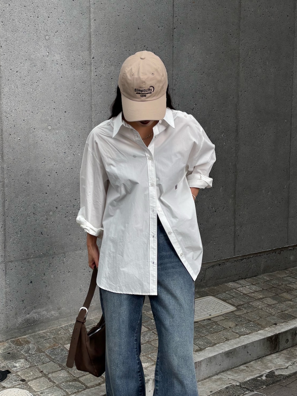 ブルー系のデニムパンツ、ブルー系のデニムパンツ、ホワイト系のスニーカーを着用したレディースの秋コーディネートの4枚目の写真