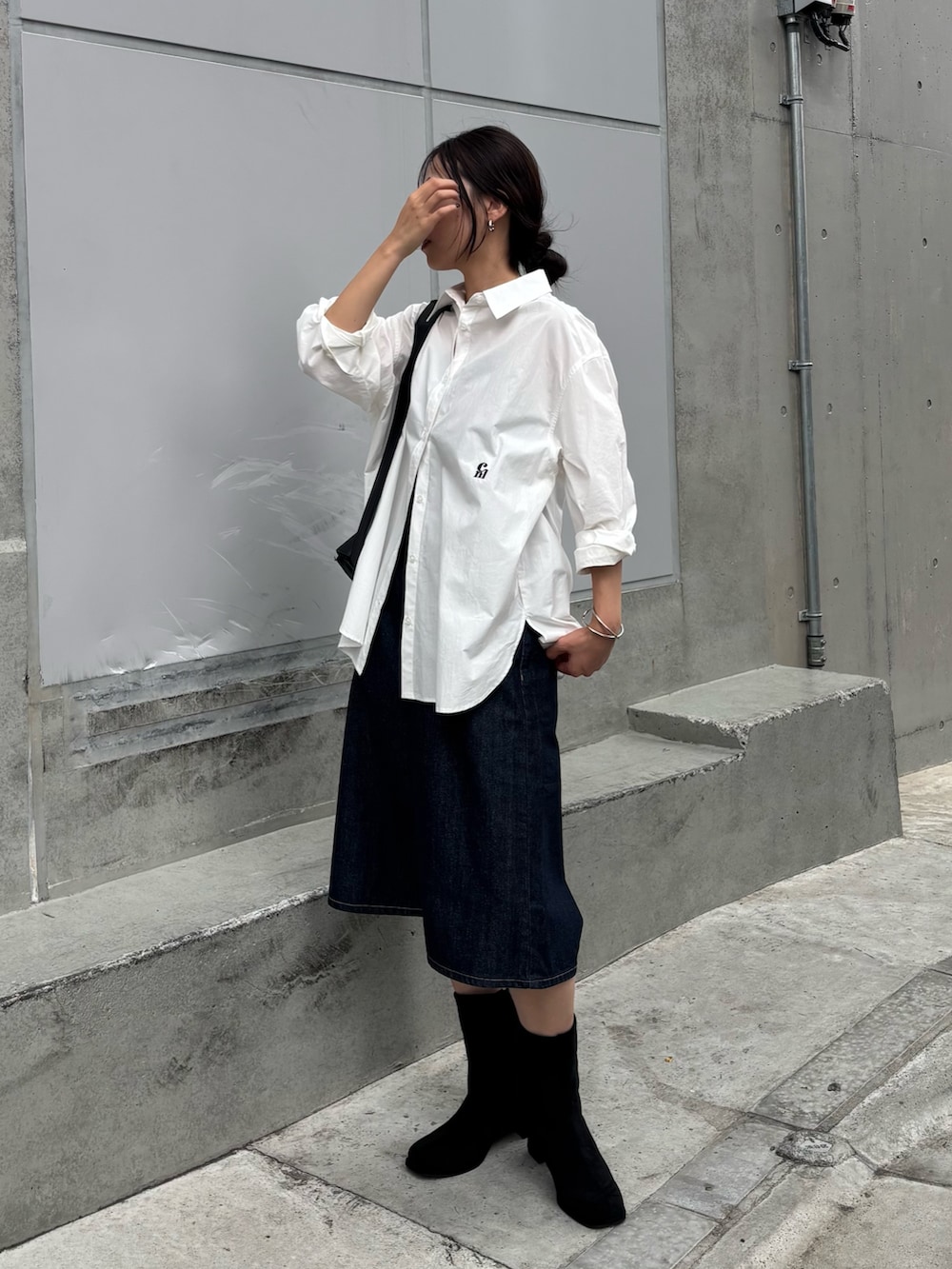 ブラック系のボディバッグ/ウエストポーチ、ホワイト系のシャツ/ブラウス、ブルー系のデニムパンツを着用したレディースの秋コーディネートの5枚目の写真