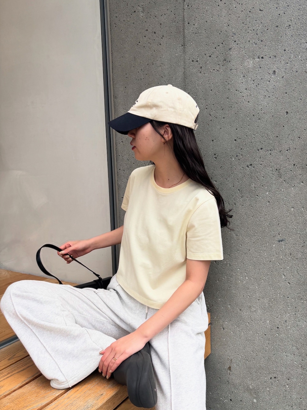 イエロー系のTシャツ/カットソー、ホワイト系のスウェットパンツ、ブラック系のレインシューズを着用したレディースの夏コーディネートの2枚目の写真