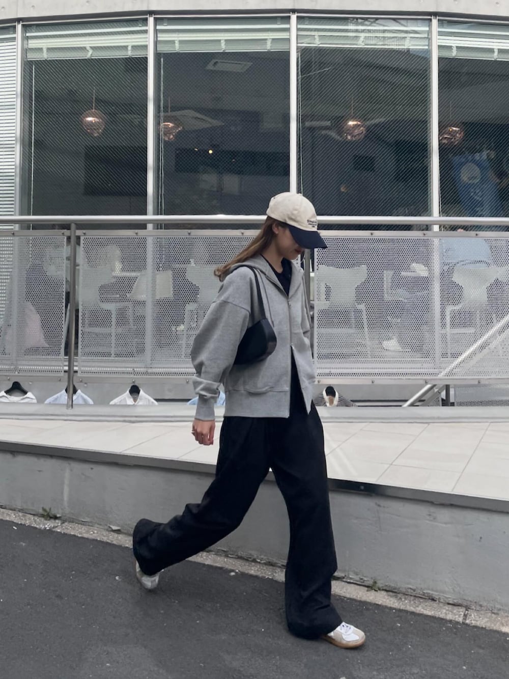 グレー系のパーカー、ホワイト系のスニーカーを着用したレディースの春コーディネートの4枚目の写真