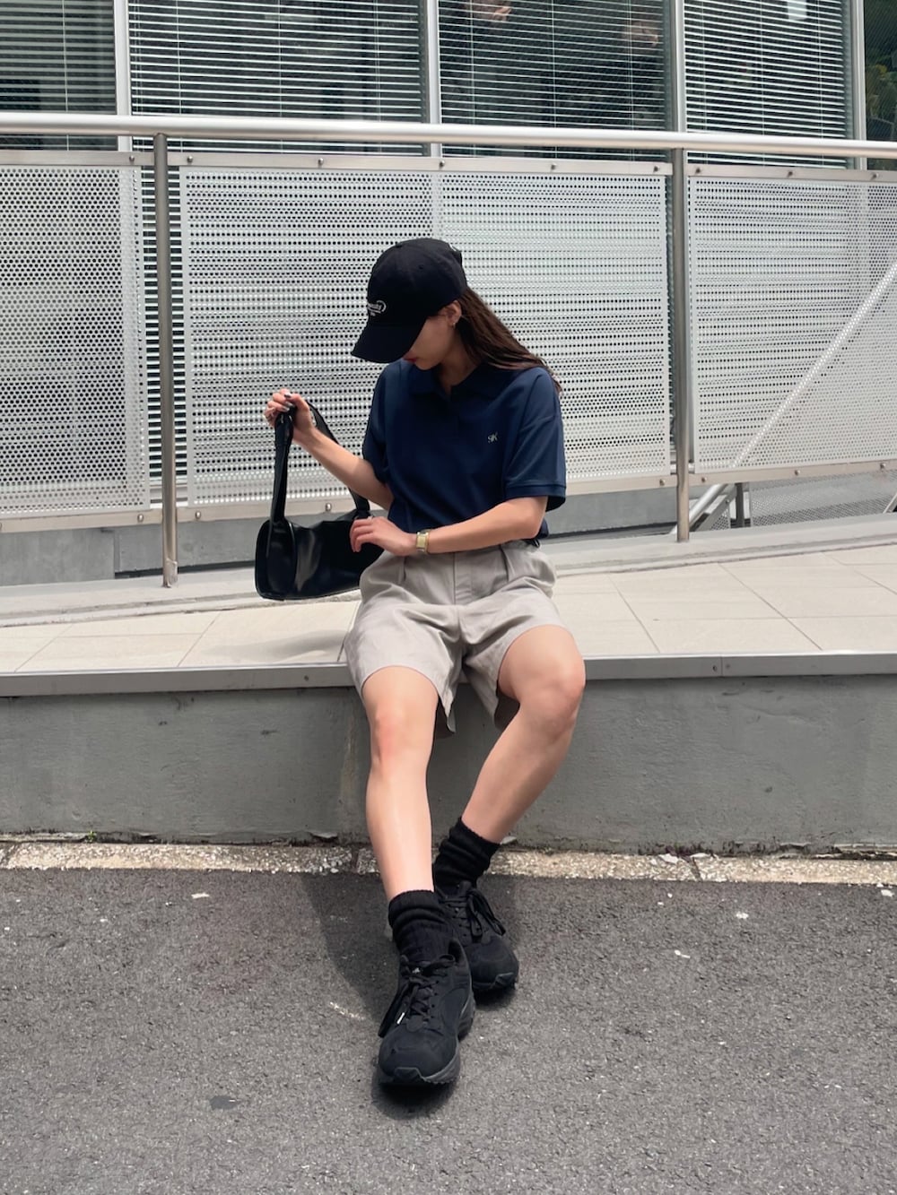 ブルー系のポロシャツ、ベージュ系のその他パンツ、ブラック系のスニーカーを着用したレディースの夏コーディネートの3枚目の写真