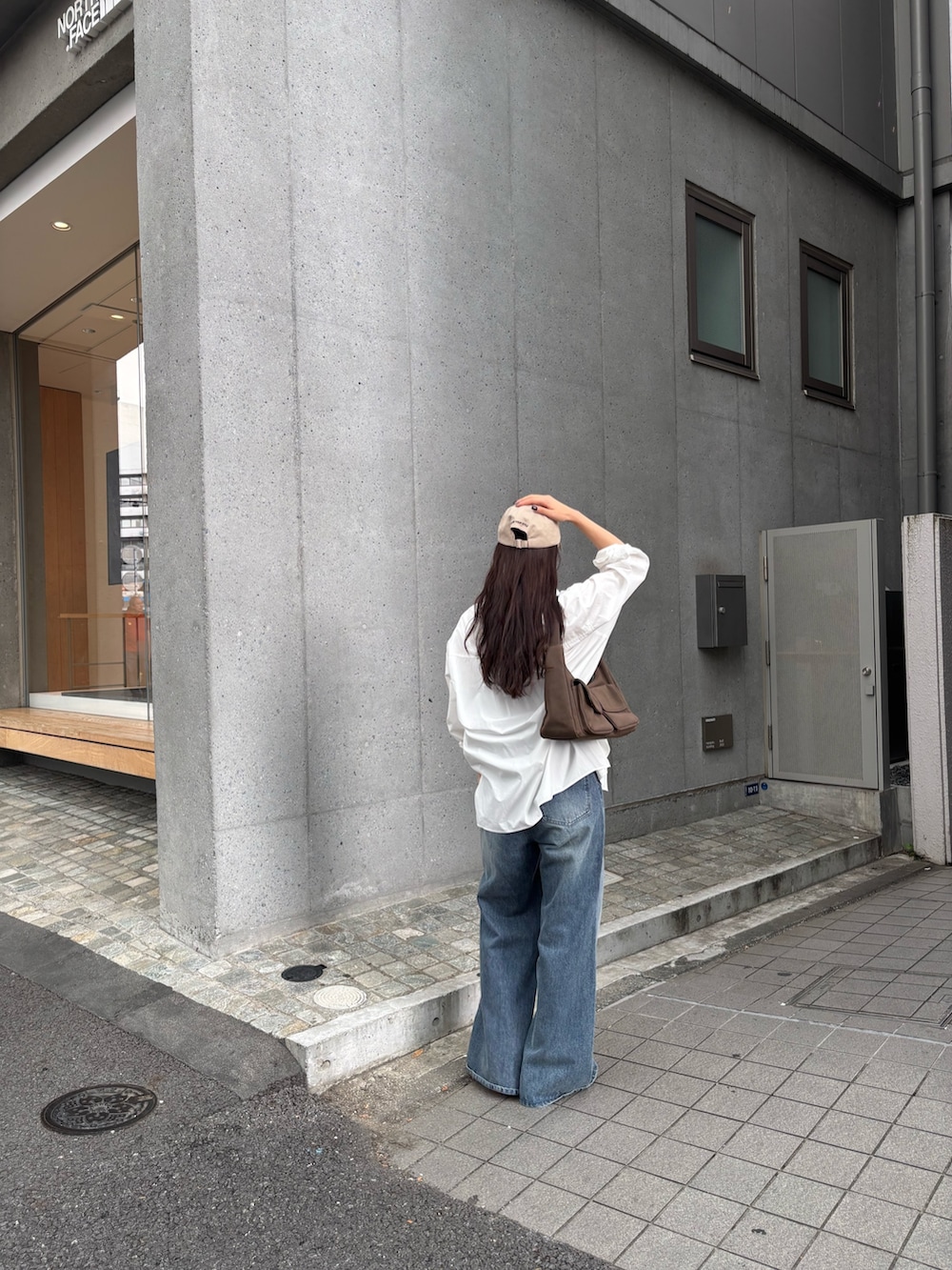 ブルー系のデニムパンツ、ブルー系のデニムパンツ、ホワイト系のスニーカーを着用したレディースの秋コーディネートの2枚目の写真