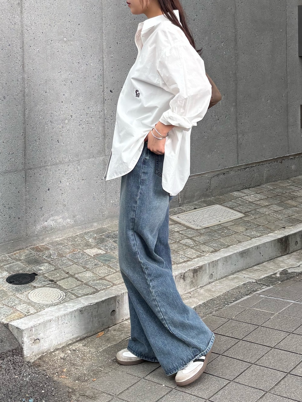 ブルー系のデニムパンツ、ブルー系のデニムパンツ、ホワイト系のスニーカーを着用したレディースの秋コーディネートの3枚目の写真