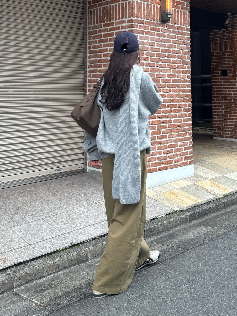 グレー系のニット/セーター、ブラウン系のショルダーバッグを着用したレディースの冬コーディネートの4枚目の写真