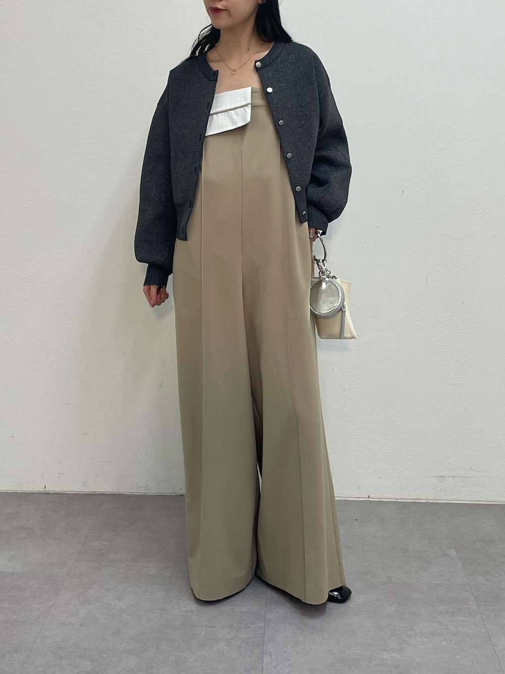 ベージュ系のつなぎ/オールインワン、グレー系のカーディガン/ボレロ、ホワイト系のショルダーバッグを着用したレディースの冬コーディネートの3枚目の写真