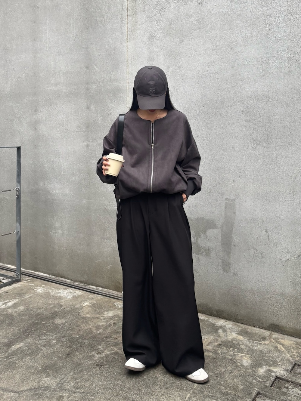 ブラック系のスラックス、ブラック系のブルゾン、ブラック系のTシャツ/カットソーを着用したレディースの冬コーディネートの4枚目の写真