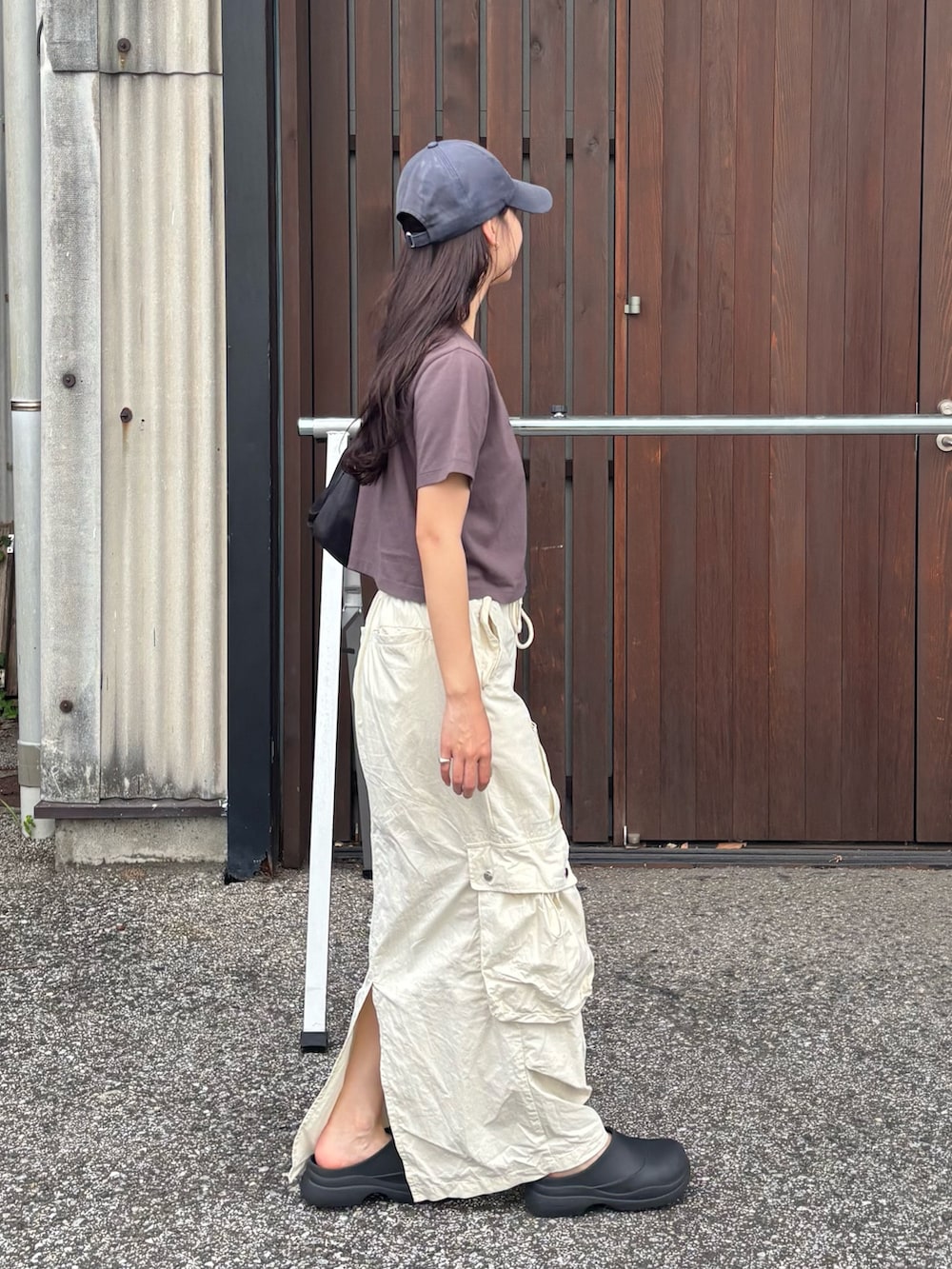 グレー系のTシャツ/カットソー、ホワイト系のスカート、ブラック系のレインシューズを着用したレディースの夏コーディネートの2枚目の写真