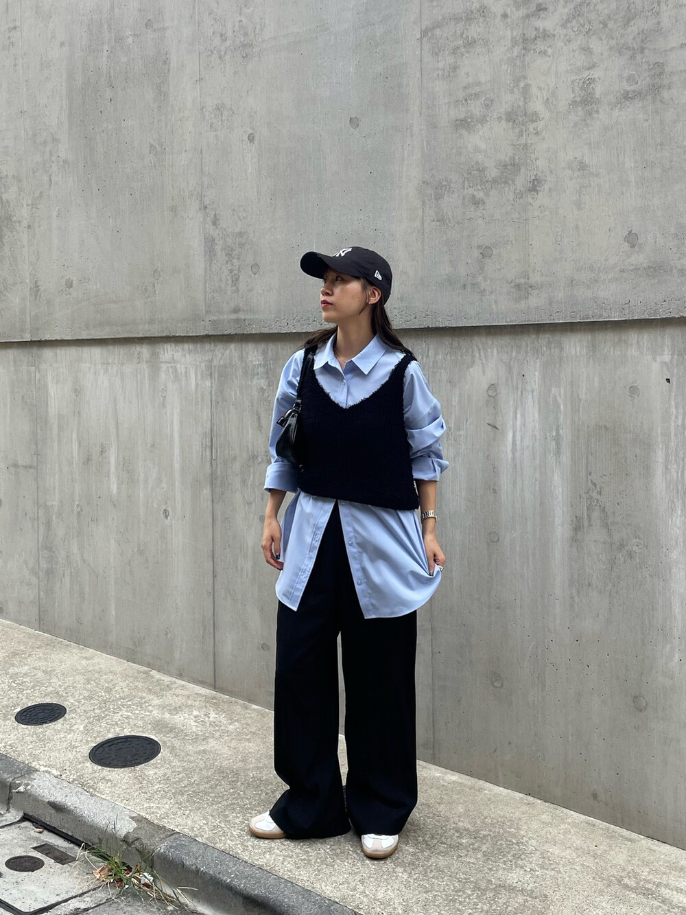 ブルー系のシャツ/ブラウス、ホワイト系のスニーカー、ブラック系のショルダーバッグを着用したレディースの秋コーディネートの3枚目の写真