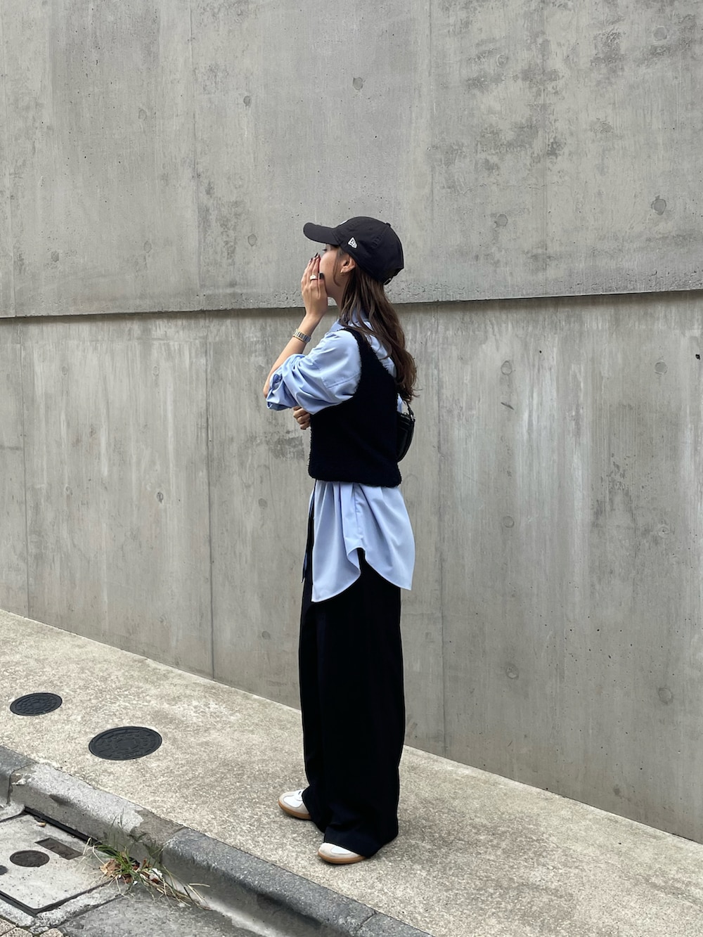 ブルー系のシャツ/ブラウス、ホワイト系のスニーカー、ブラック系のショルダーバッグを着用したレディースの秋コーディネートの4枚目の写真