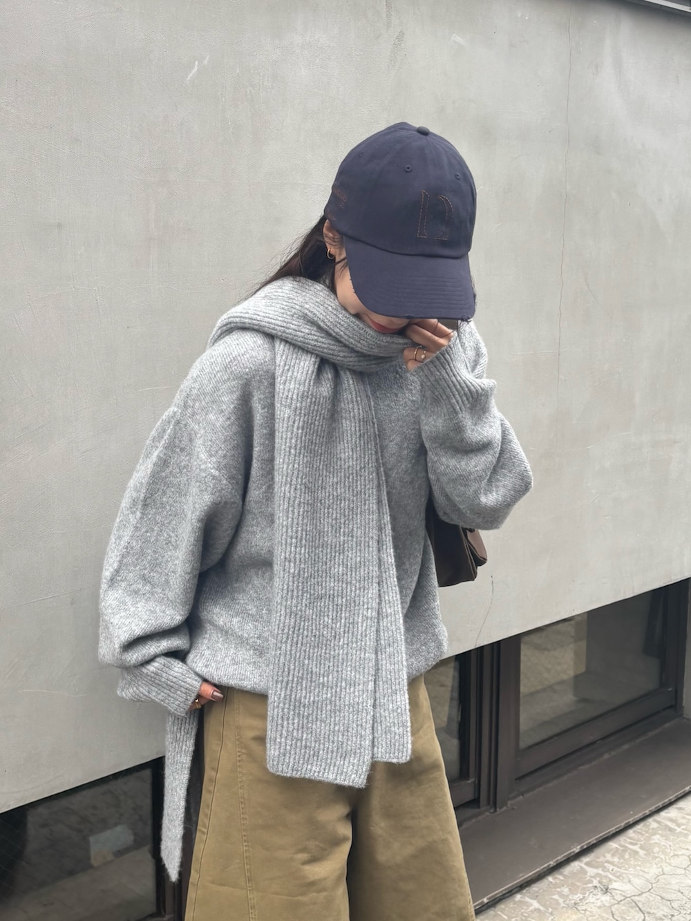 グレー系のニット/セーター、ブラウン系のショルダーバッグを着用したレディースの冬コーディネートの5枚目の写真