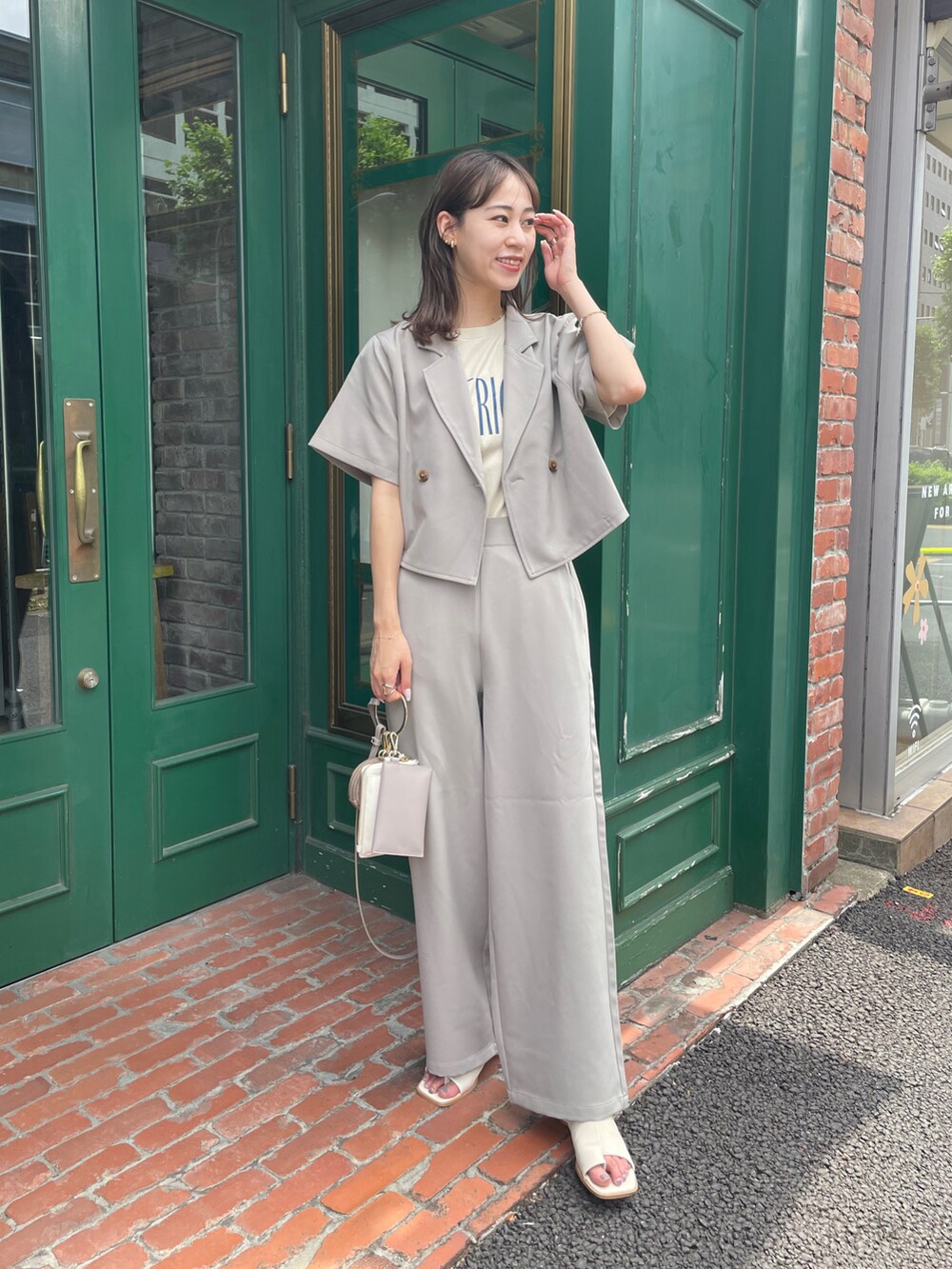 ベージュ系のセットアップ、ホワイト系のサンダル、ベージュ系のショルダーバッグを着用したレディースの夏コーディネートの4枚目の写真