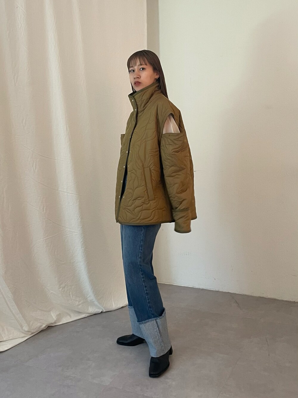 ブルー系のデニムパンツ、グリーン系のブルゾン、ブラック系のブーツを着用したレディースの夏コーディネートの5枚目の写真