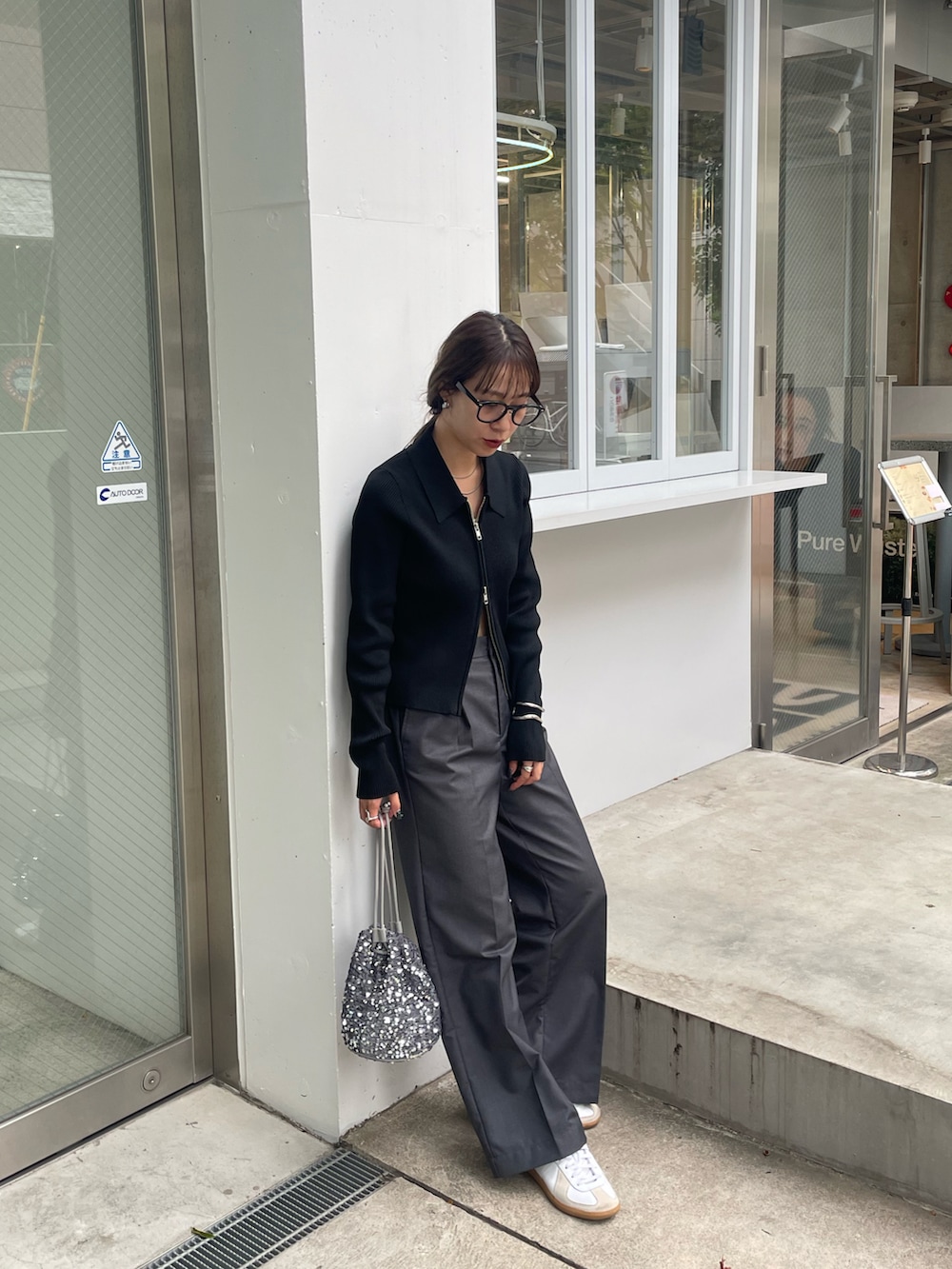 グレー系のスラックス、シルバー系のショルダーバッグ、ホワイト系のスニーカーを着用したレディースの秋コーディネートの3枚目の写真