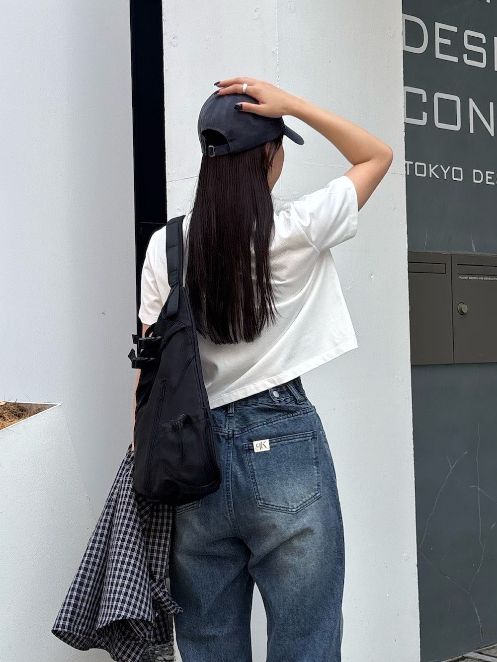 ブルー系のデニムパンツ、ホワイト系のTシャツ/カットソー、ブラック系のボディバッグ/ウエストポーチを着用したレディースの秋コーディネートの5枚目の写真